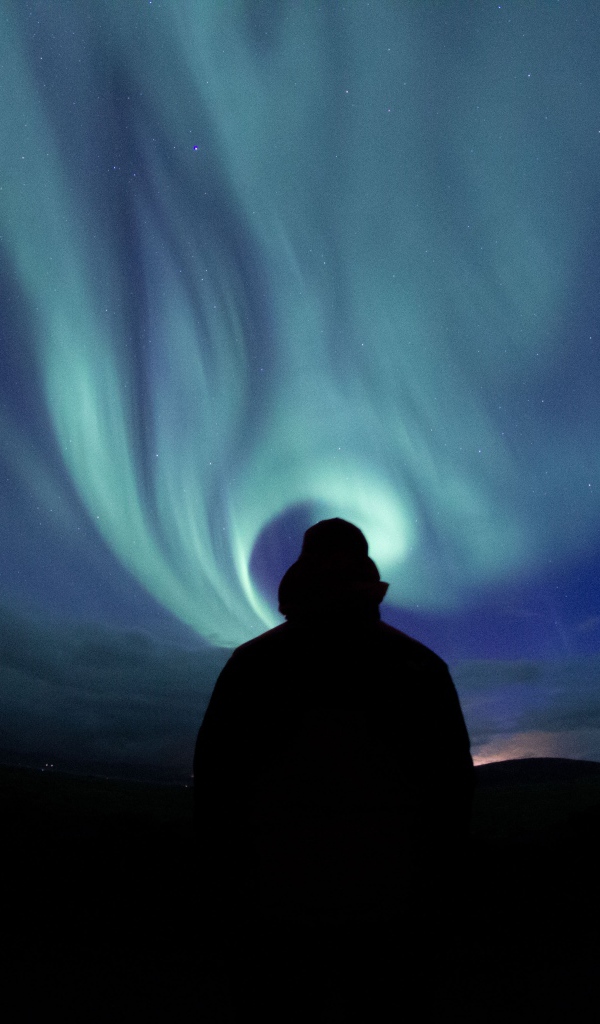 Силуэт мужчины на фоне неба с полярным сиянием
