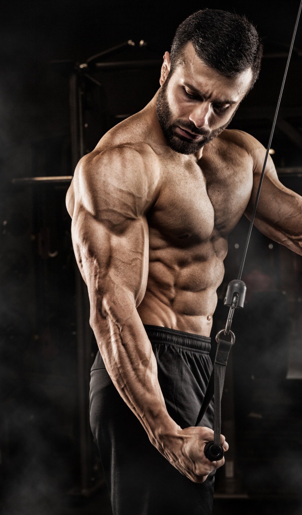 Сильный мужчина бодибилдер в спортзале