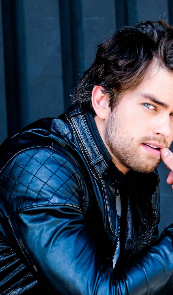 Красивый мужчина, актер Пирсон Фоде в черной кожаной куртке