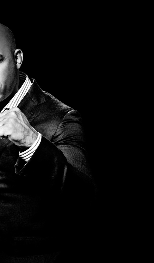 Популярный актер Вин Дизель в костюме на черном фоне