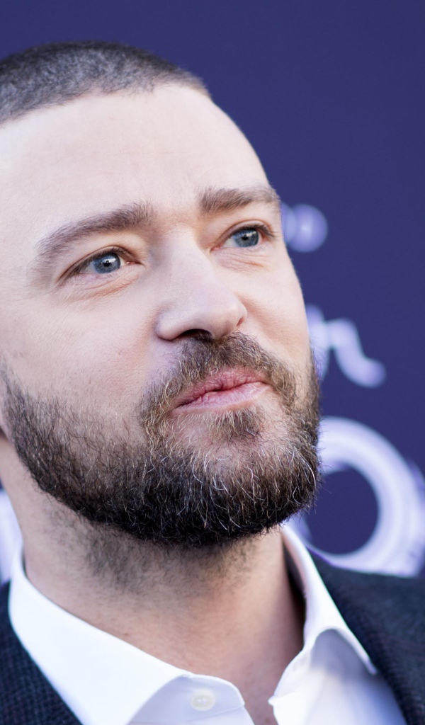 Лицо голубоглазого актера Джастина Тимберлейка на синем фоне