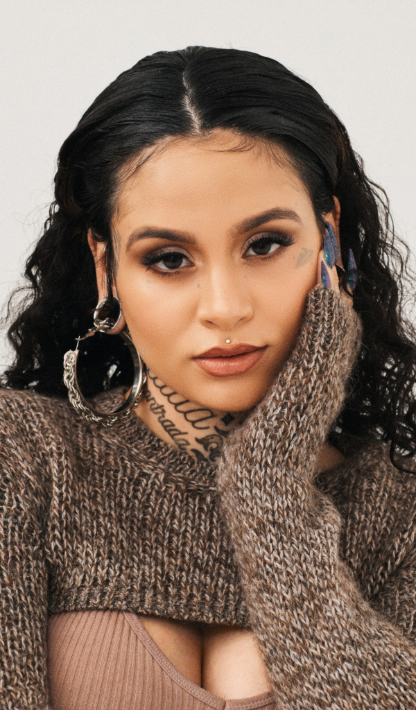 American singer Keilani in a sweater on a gray background
