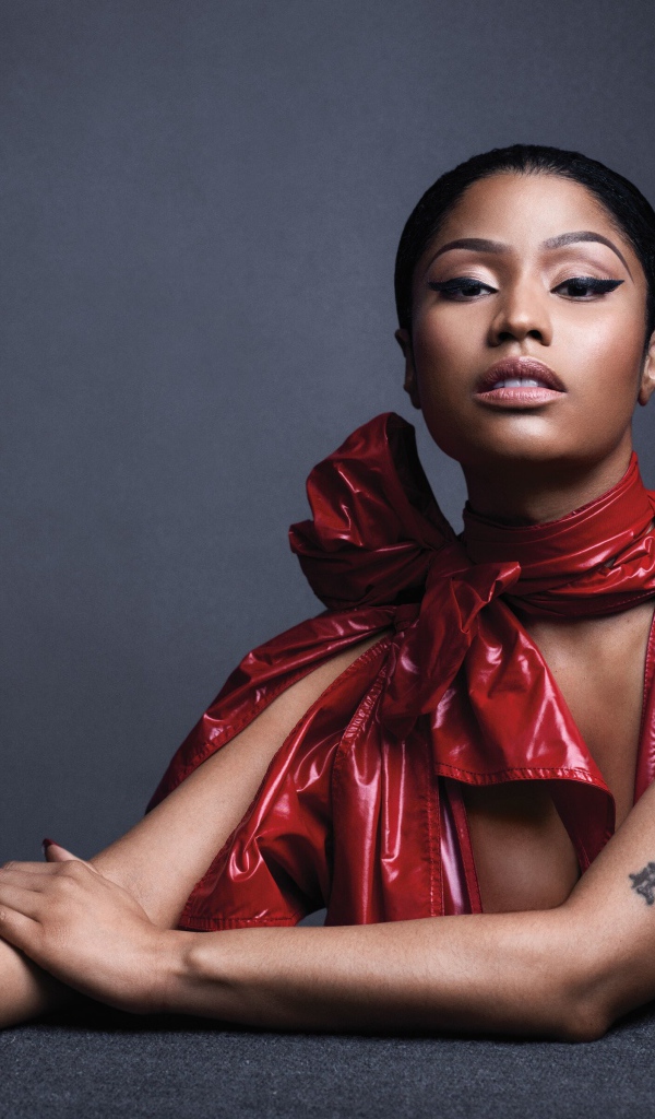 Американская певица, рэпер Ники Минаж  в красном наряде на сером фоне