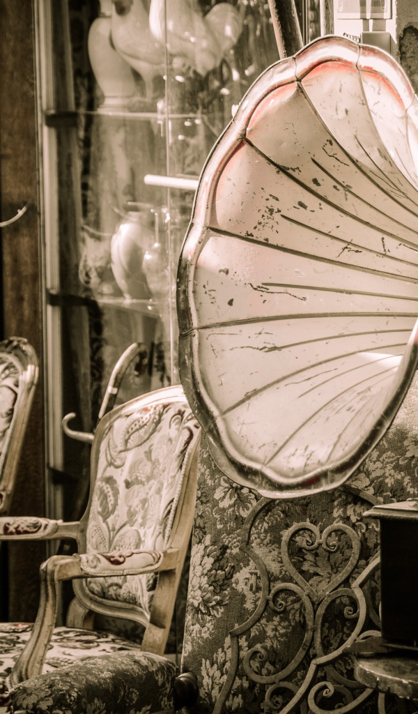 Большой старый граммофон в комнате со стульями