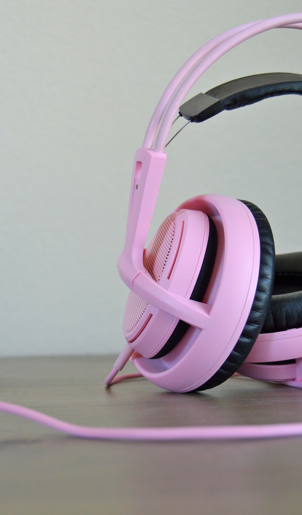 Большие розовые наушники на столе 