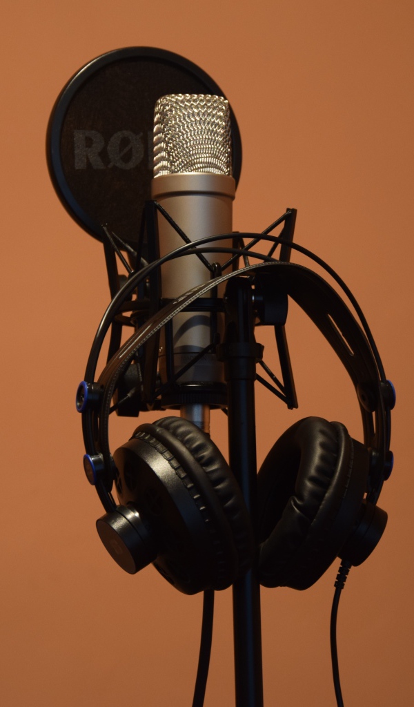 Конденсаторный микрофон с наушниками на коричневом фоне