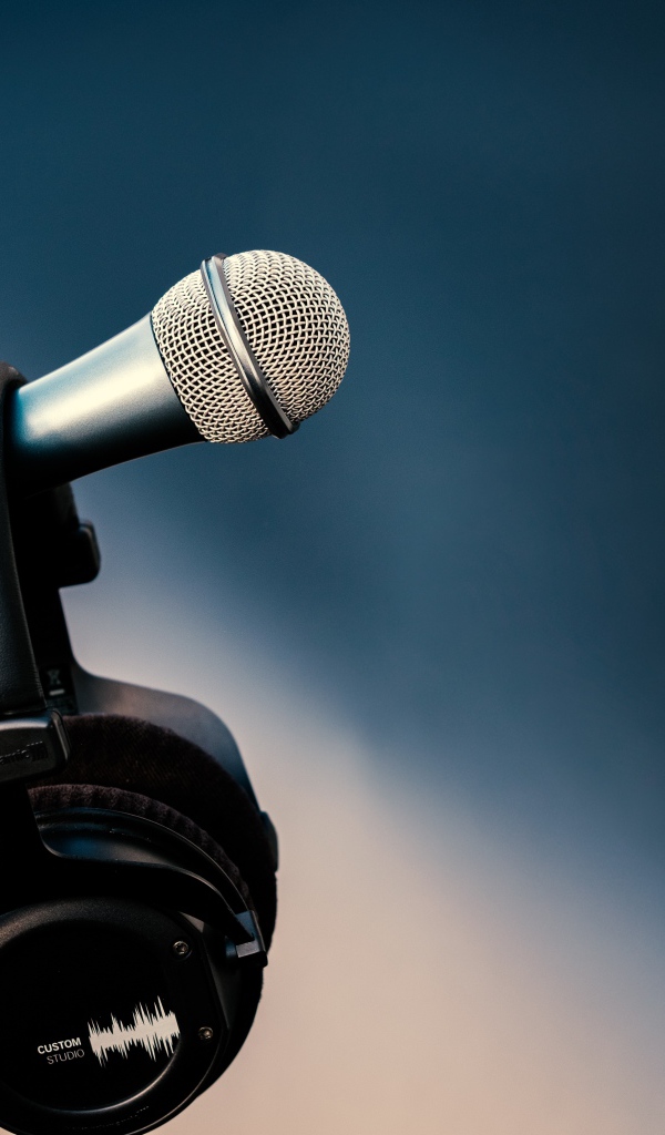 Микрофон с черными наушниками на стойке 