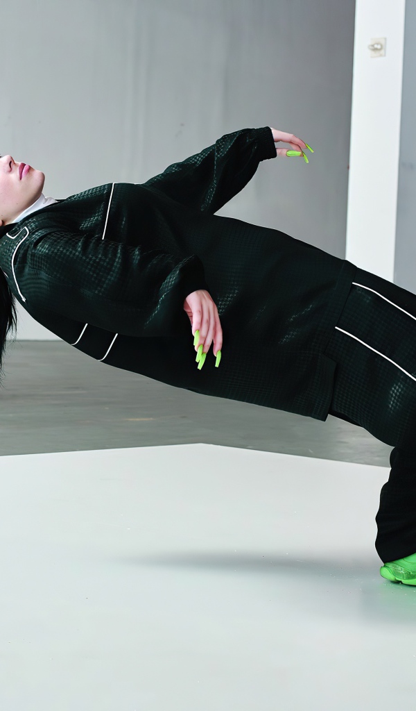 Певица Билли Айлиш в черном спортивном костюме 