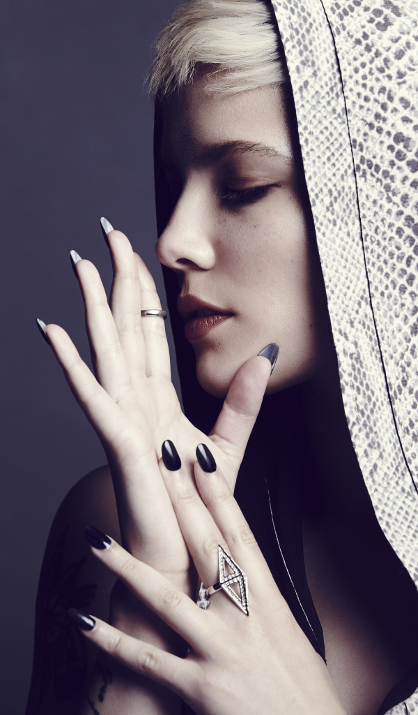 Певица Холзи в капюшоне на сером фоне