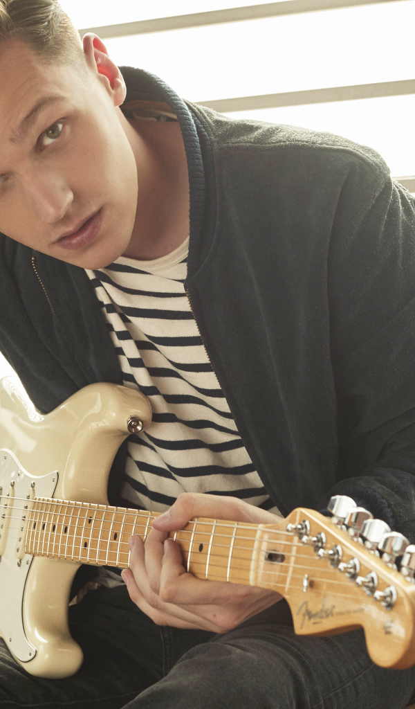 Певец Патрик Дрони с гитарой в руках