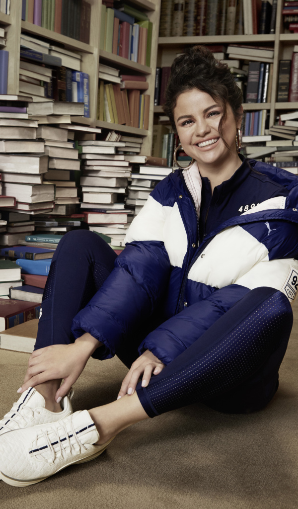 Улыбающаяся певица Селена Гомез в библиотеке 