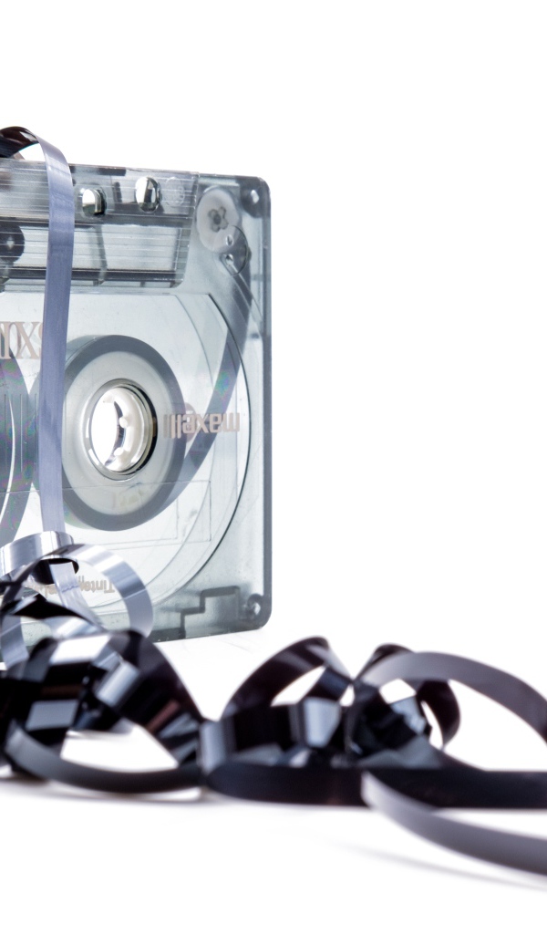 Магнитофонная кассета в размотанной пленкой на белом фоне