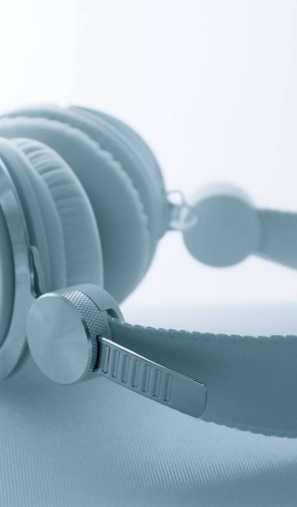 Белые большие наушники лежат на белом фоне