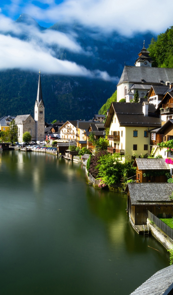 Красивые дома на берегу спокойного озера у подножия гор 