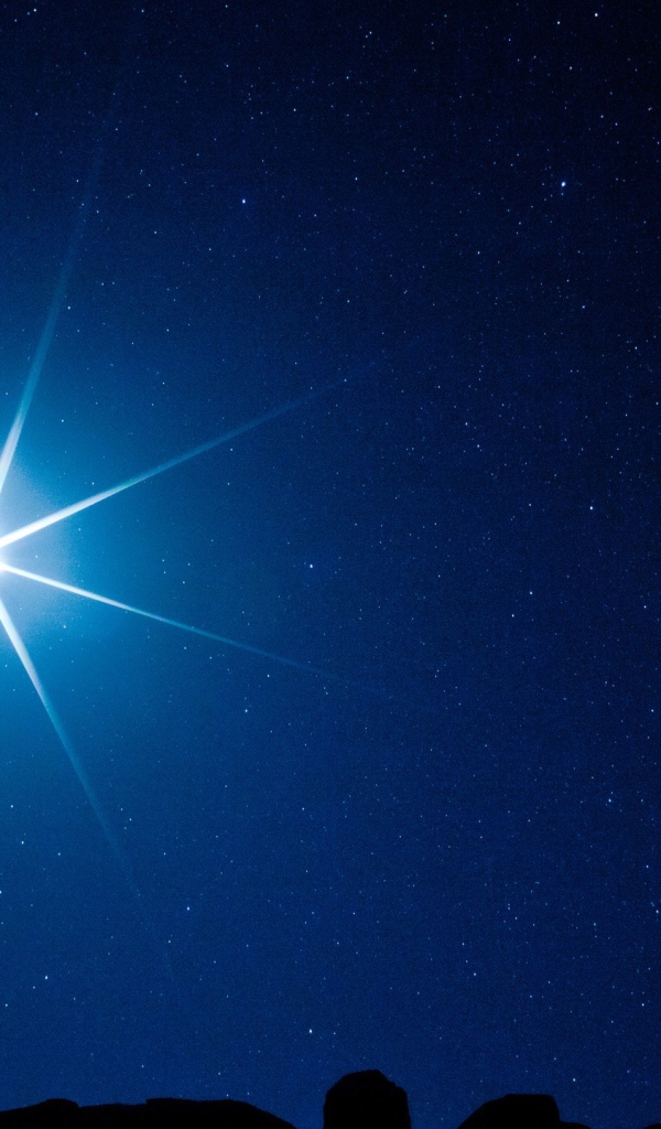 Яркая белая звезда в темном ночном небе 