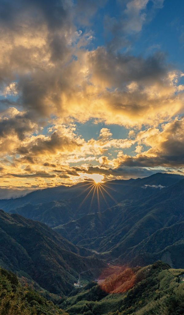 Рассвет солнца в облачном небе над горами 