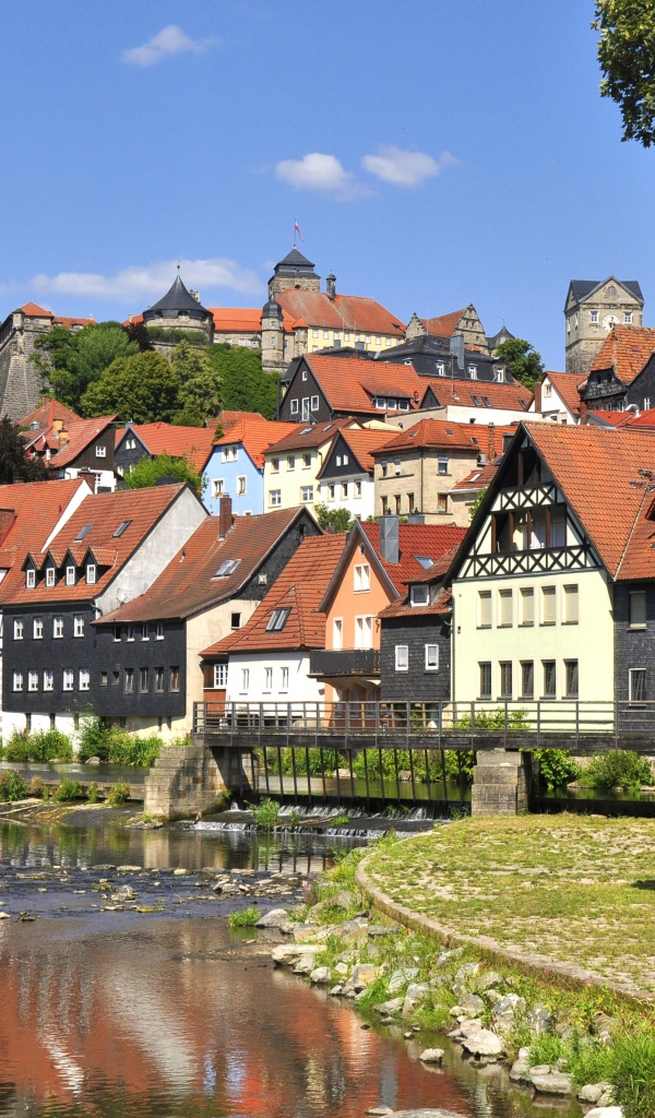 Много домов у пруда на фоне голубого неба