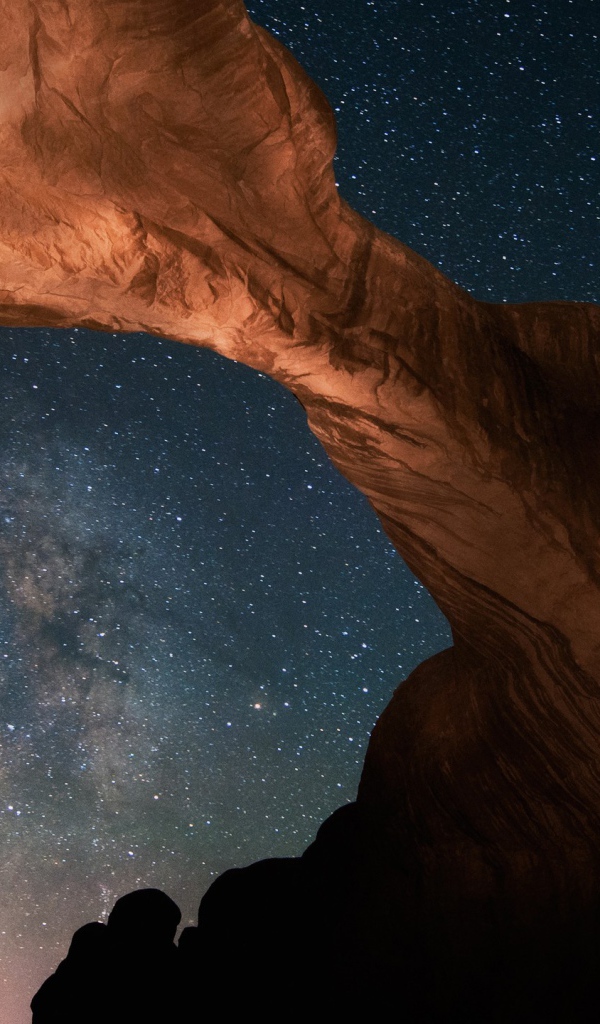 Каменная природная арка под звездным небом ночью 