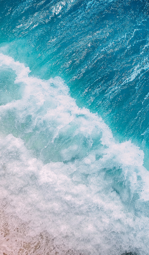 Бурные белые волны океана на песке 