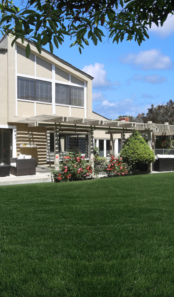 Двухэтажный дом с зеленым газоном 