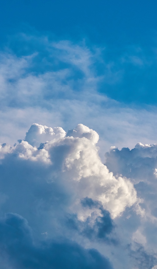 Густые белые облака в голубом небе  в лучах солнца