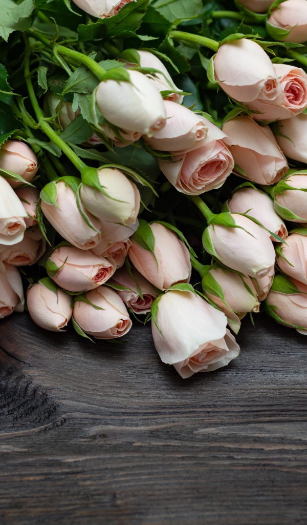 Большой букет розовых роз на деревянном столе 