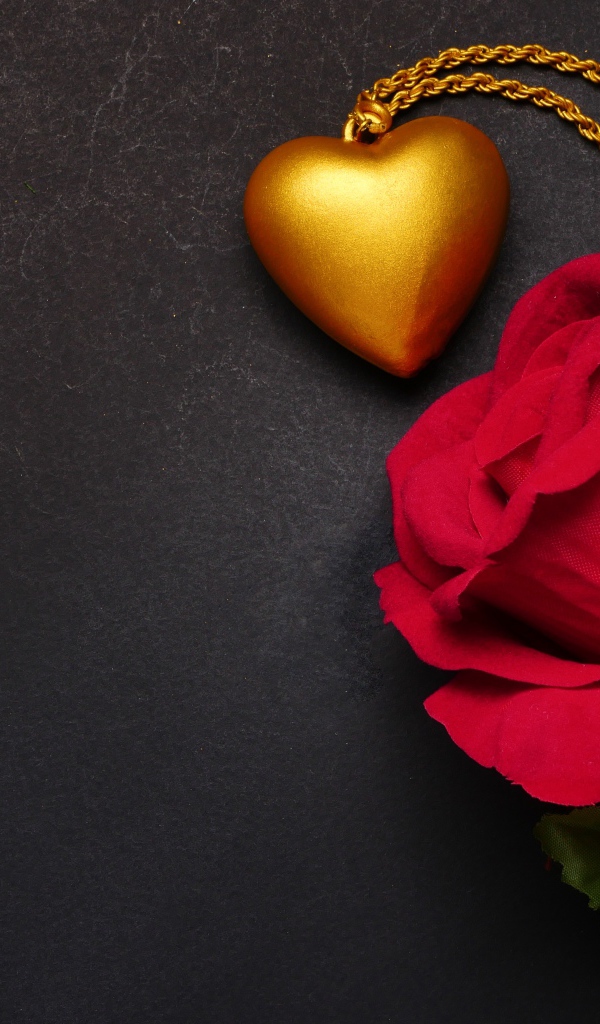 Искусственная красная роза с кулоном на сером фоне