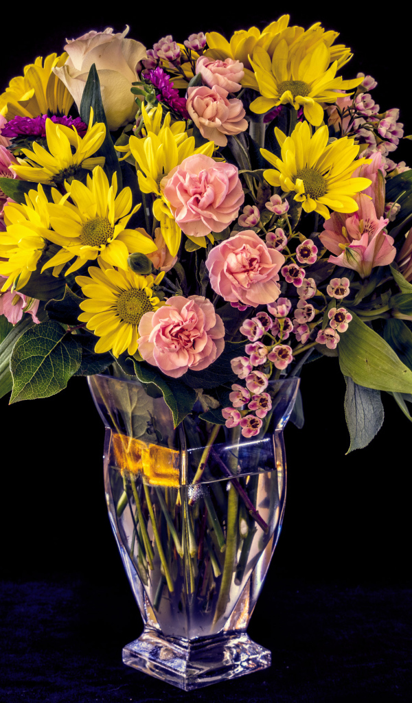 Букет красивых разноцветных цветов в вазе на черном фоне