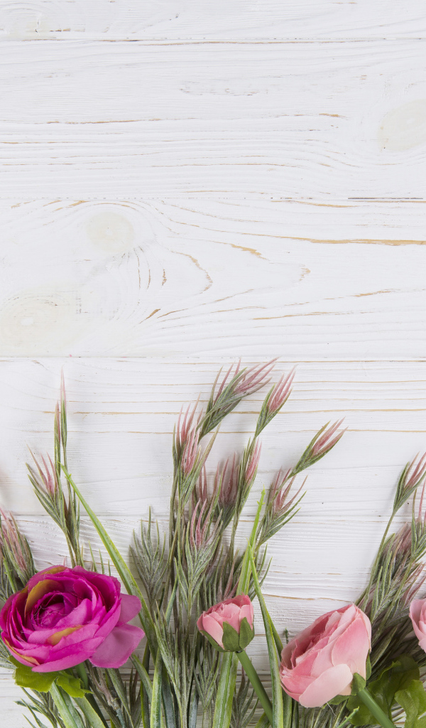 Букет разноцветных лютиков на белом столе