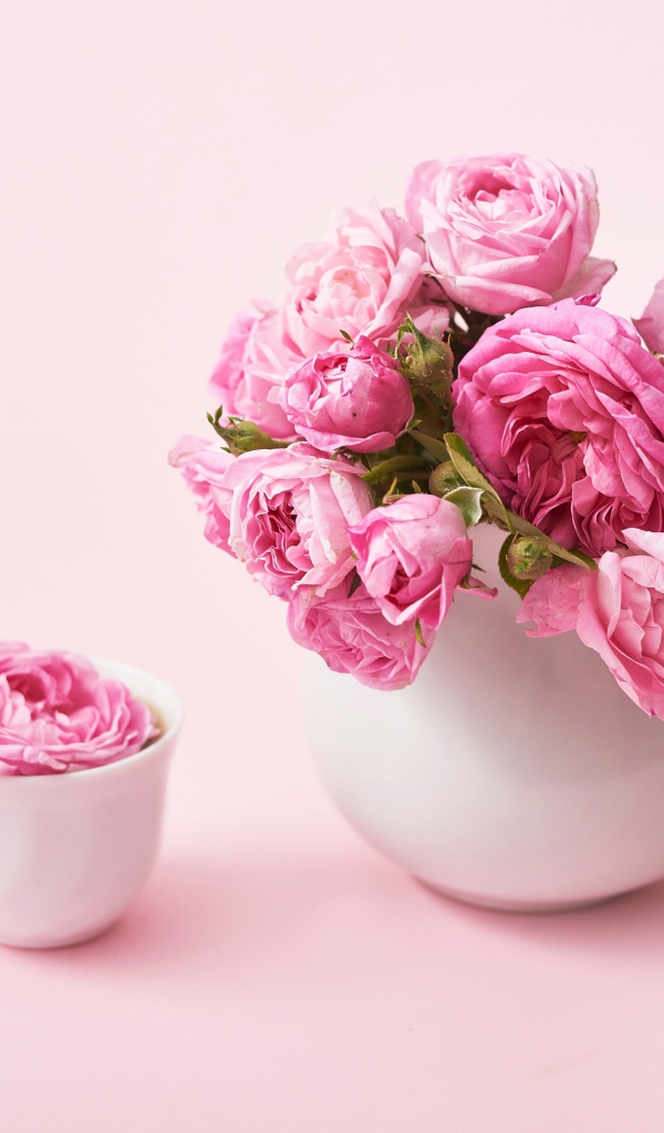 Букет розовых роз в белом кувшине на столе