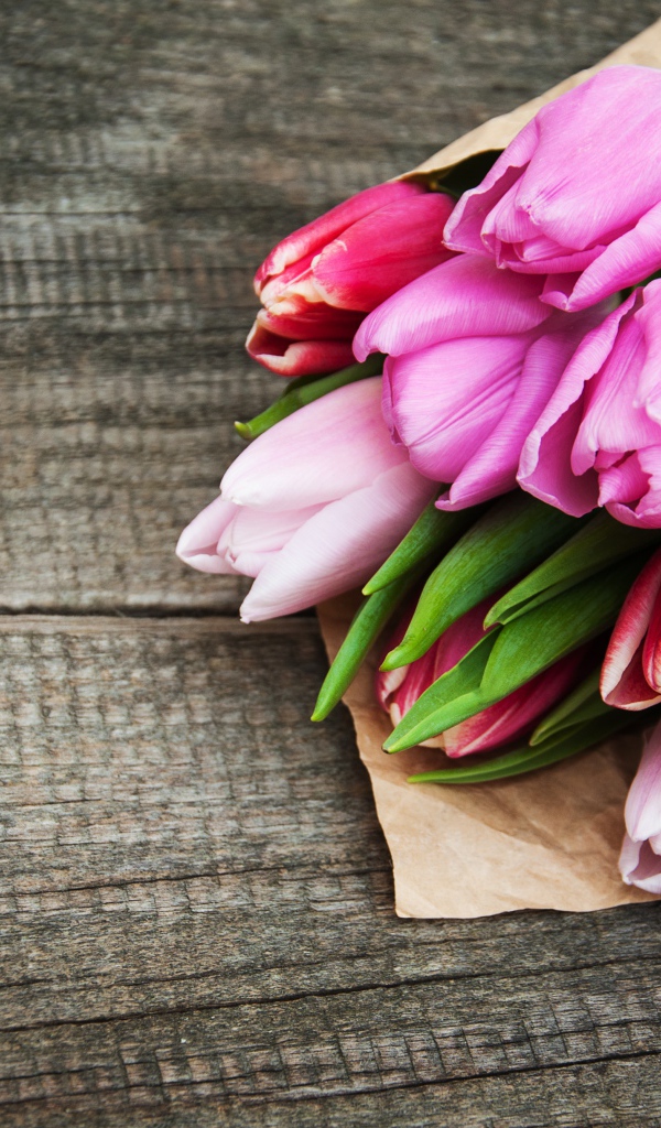 Букет розовых тюльпанов на деревянном столе 