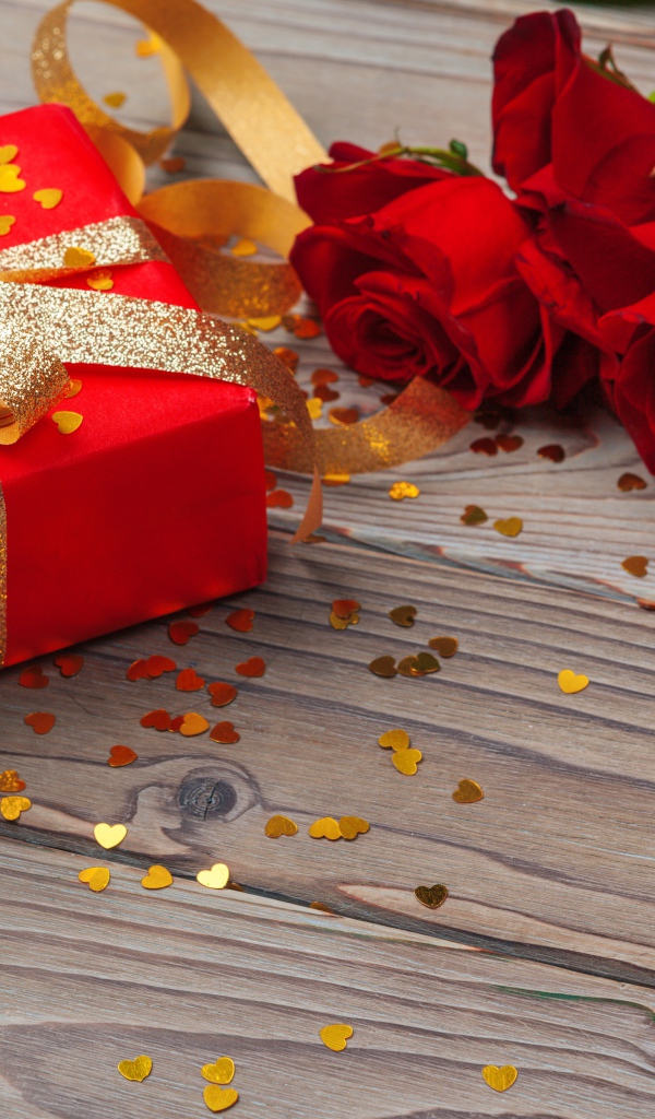 Букет красный роз с большим подарком на столе