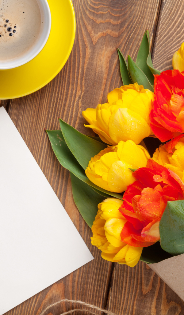 Букет тюльпанов на столе с листом бумаги и чашкой кофе