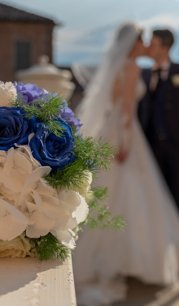 Свадебный букет на фоне новобрачной пары 