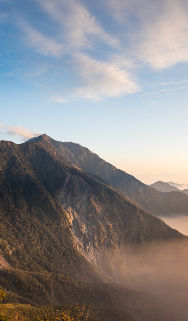 Красивый вид на покрытые туманом горы под голубым небом