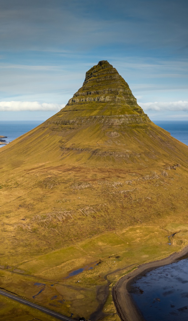 Зеленая гора Киркьюфетль под голубым небом, Исландия