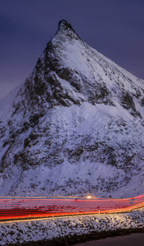 Ночная дорога у заснеженных гор 
