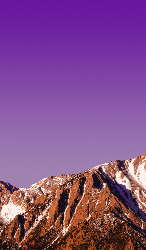 Вершины заснеженных гор на фоне сиреневого заката