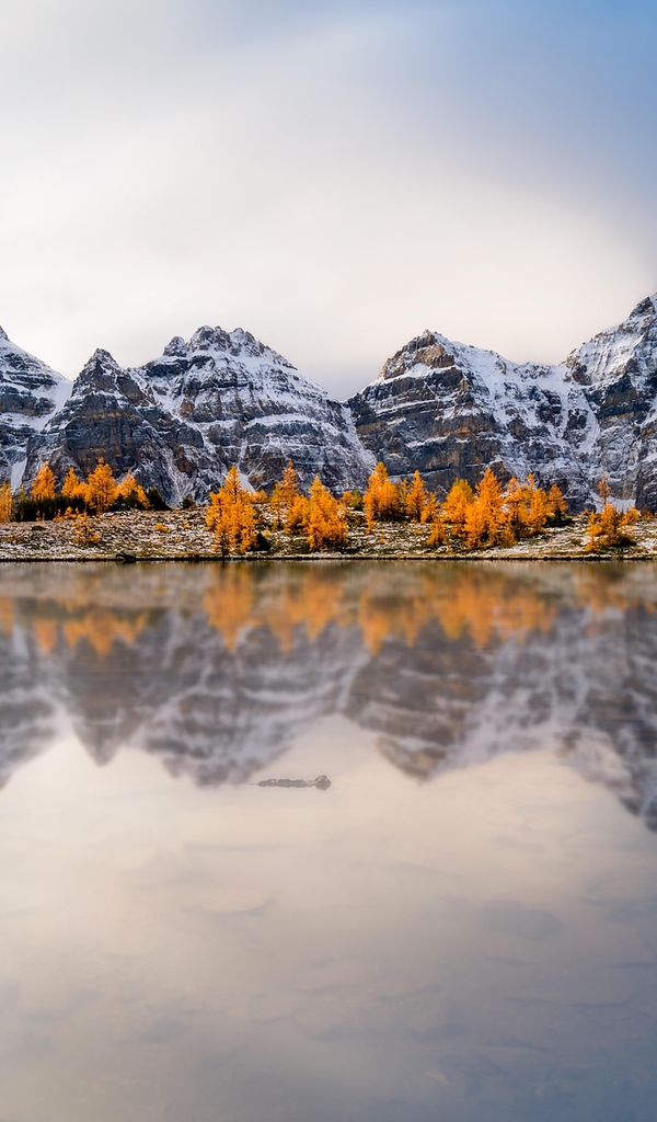 Заснеженные горы отражаются в воде озера 