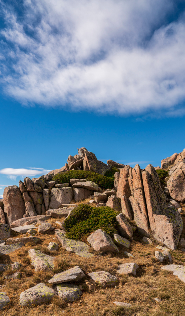 Каменные горы под голубым небом с белыми облаками 