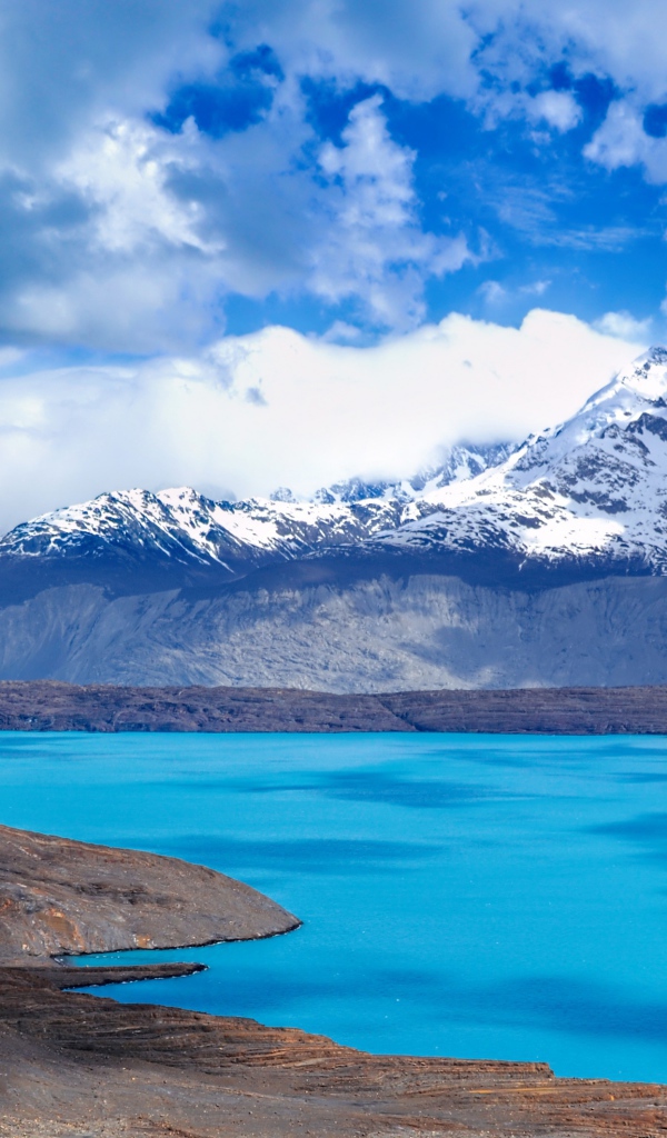 Вид на заснеженную вершину горы у голубого озера 