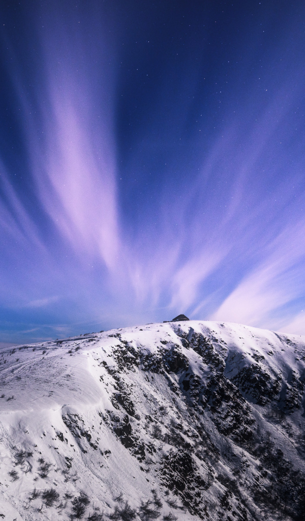 Белые облака в голубом небе над заснеженными горами