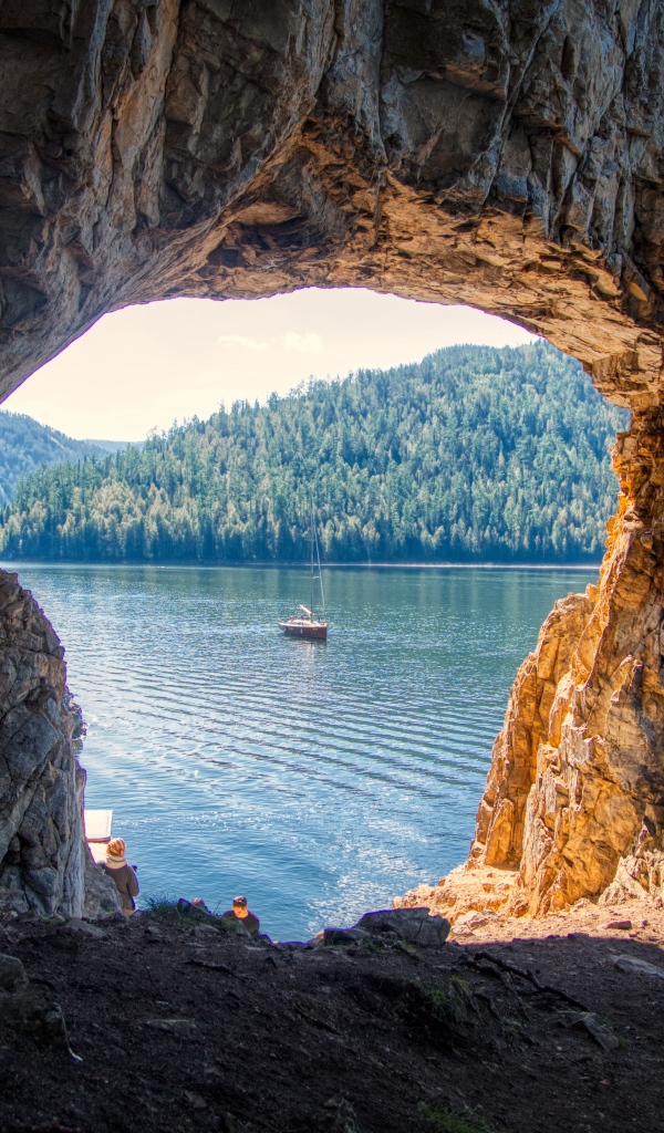 Проход арка в скале ведет к озеру