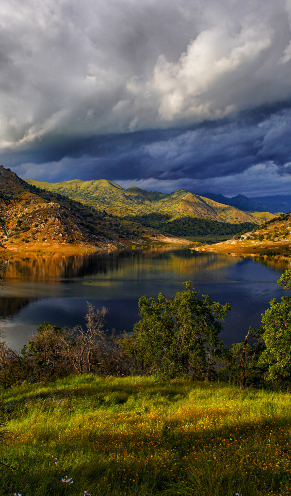 Черные грозовые облака над озером в горах 