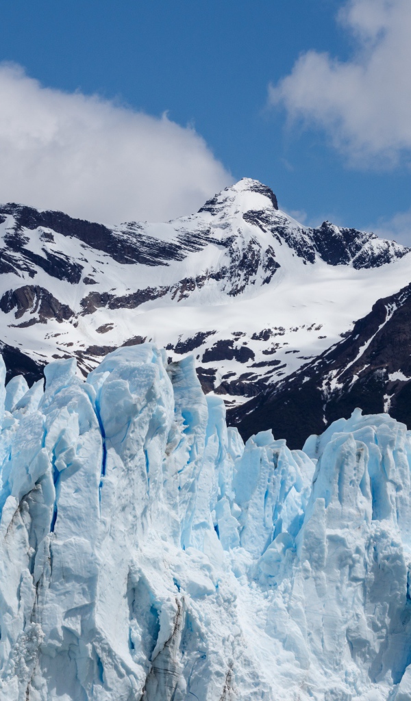 Голубой ледник на фоне заснеженных гор 