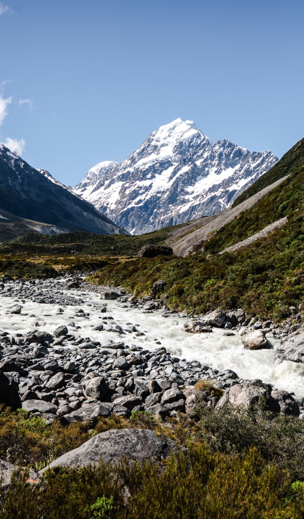 Заледеневшая река на фоне заснеженных гор 