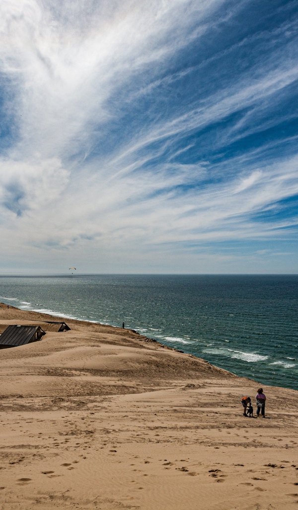 Маяк на песке на берегу моря под голубым небом