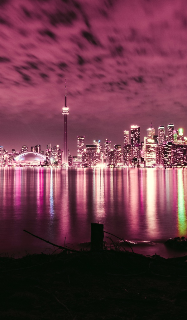 Ночной город под голубым небом отражается в воде 