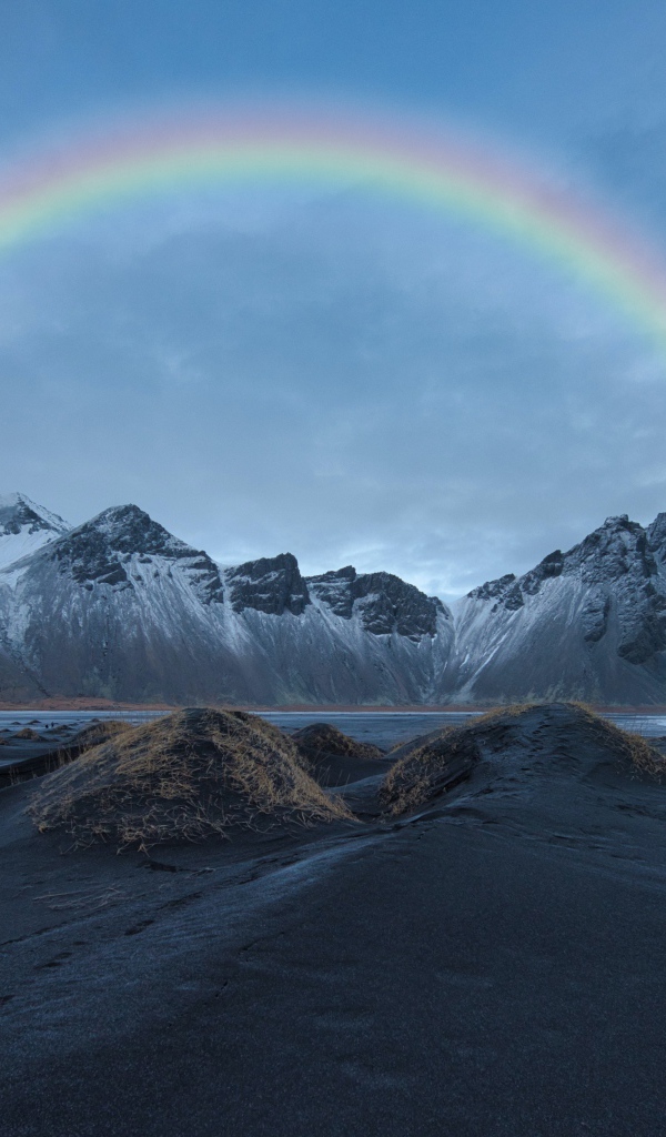 Радуга в небе над высокими горами