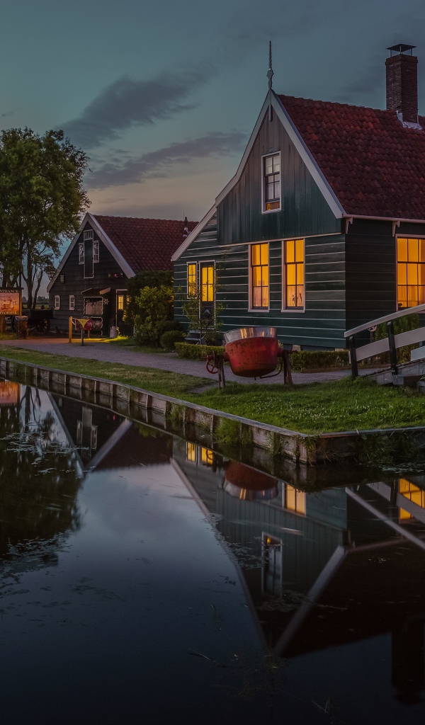 Маленькие дома у пруда вечером 